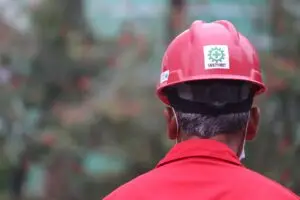 Industrial worker with a red safety helmet labeled "Safety First," symbolizing the importance of LED lighting in improving productivity and safety in industrial environments