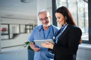 Healthcare professionals discussing technology integration and efficient LED lighting systems in a hospital environment