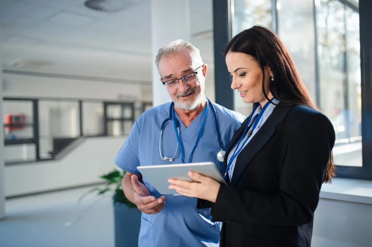 Healthcare professionals discussing technology integration and efficient LED lighting systems in a hospital environment